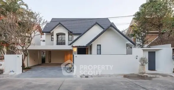 Modern two-story house with sleek design and spacious driveway in a serene neighborhood.