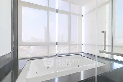 Luxurious bathroom with city view and modern bathtub in high-rise apartment.