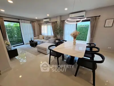 Modern living room with elegant dining area and large windows overlooking greenery.