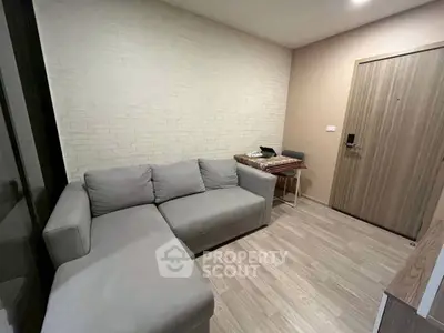 Cozy living room with modern gray sofa and stylish brick accent wall