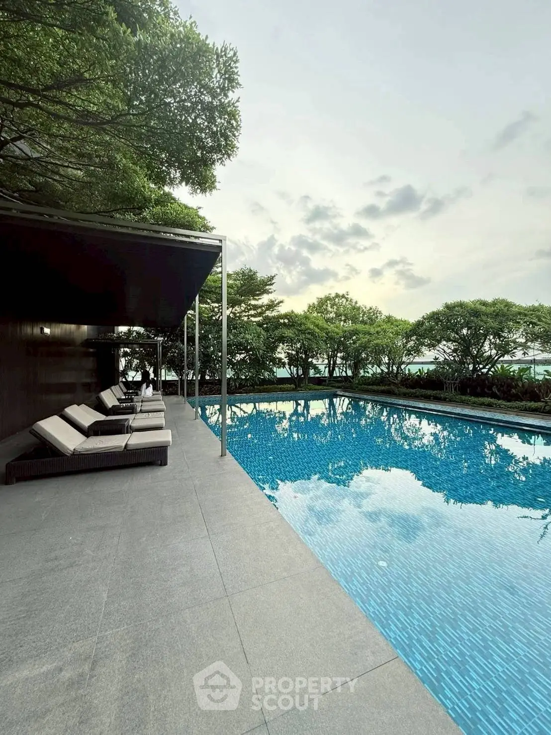 Luxurious outdoor pool area with serene surroundings and modern lounge chairs, perfect for relaxation.