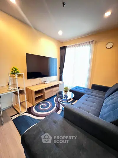 Modern living room with stylish furniture and large TV, perfect for relaxation and entertainment.
