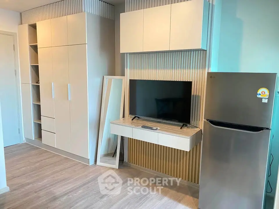 Modern apartment interior with sleek cabinetry and stainless steel fridge