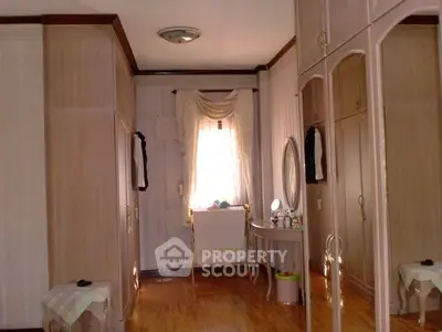 Elegant bedroom with wooden flooring and classic wardrobe design