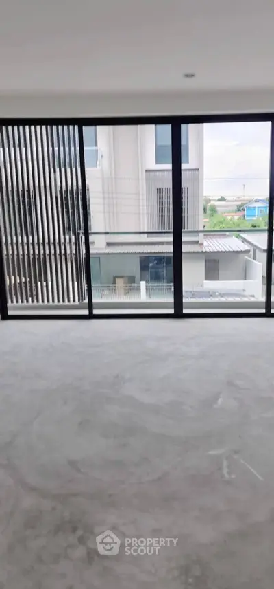 Spacious modern apartment with floor-to-ceiling windows and urban view.