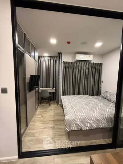 Modern bedroom with stylish decor and workspace in a contemporary apartment.