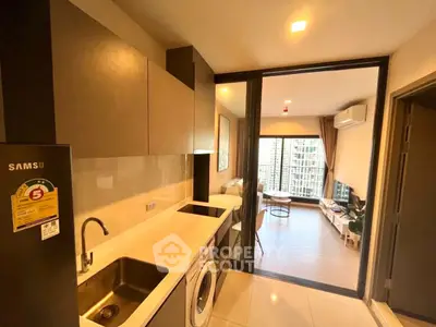 Modern kitchen with sleek appliances and open view to stylish living room