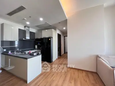 Modern open-layout kitchen with sleek appliances and wooden flooring