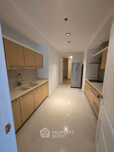 Modern kitchen with sleek cabinetry and stainless steel appliances in a spacious apartment.