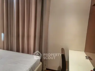 Cozy bedroom with elegant curtains and a sleek study desk, perfect for a modern living space.