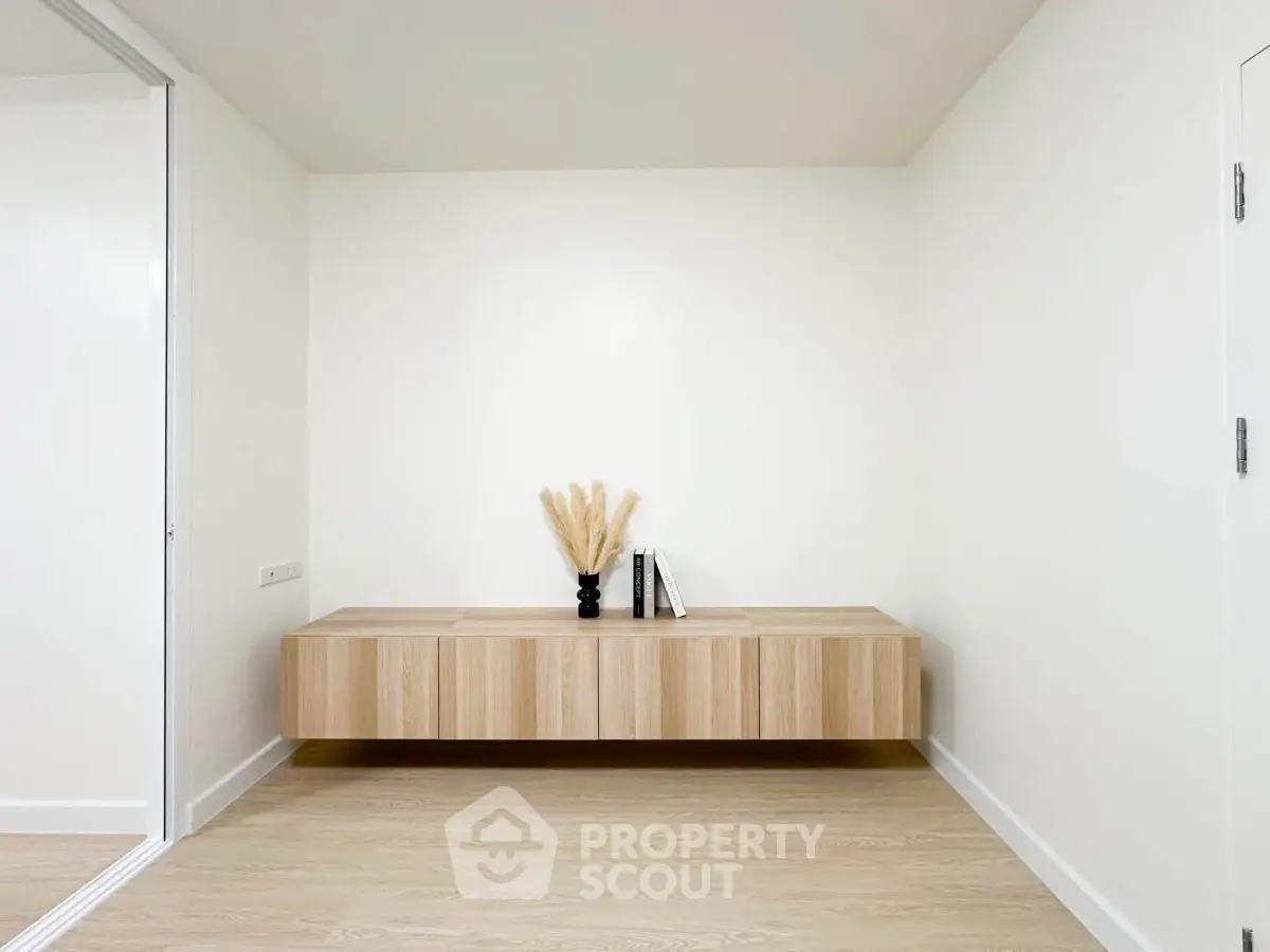 Minimalist interior with floating wooden cabinet and decorative vase, perfect for modern living spaces.