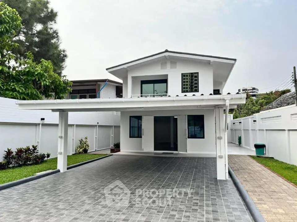 Stunning modern two-story house with spacious driveway and lush greenery, perfect for family living.