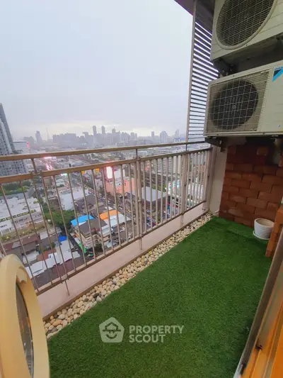 Charming balcony with artificial grass and city skyline view, perfect for relaxation.