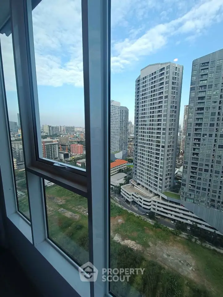 Stunning urban view from high-rise apartment window showcasing modern cityscape.