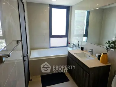 Modern bathroom with sleek design, featuring a bathtub and large window for natural light.