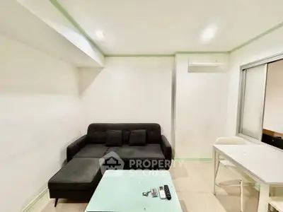 Modern living room with sleek black sofa and minimalist decor, perfect for urban living.