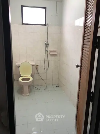 Simple bathroom with shower and toilet in a tiled space