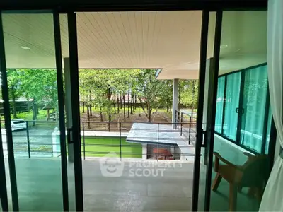 Spacious balcony with serene garden view and modern sliding glass doors