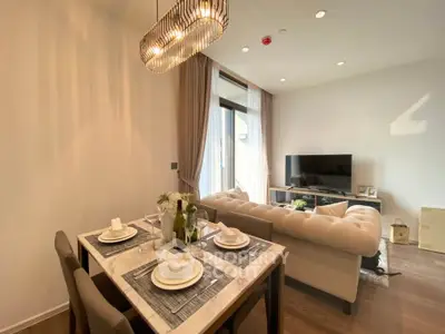 Elegant living room with dining area, featuring modern chandelier and cozy seating, perfect for entertaining.