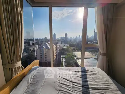 Stunning bedroom with floor-to-ceiling windows offering breathtaking city skyline views.