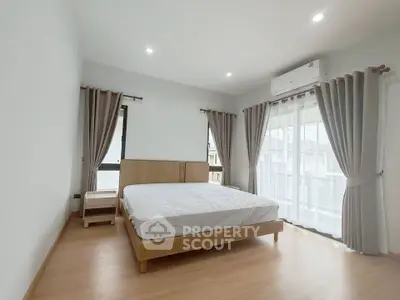 Spacious bedroom with natural light and modern decor in a stylish apartment.