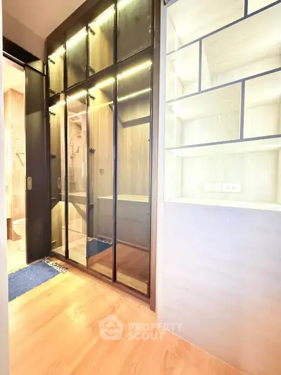 Modern interior with sleek glass wardrobe and built-in shelving