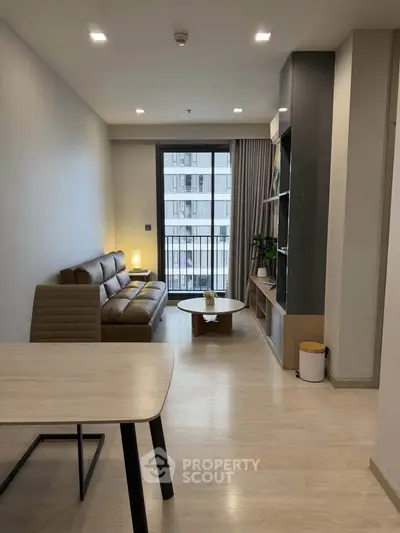 Modern living room with sleek furniture and large window in a stylish apartment.