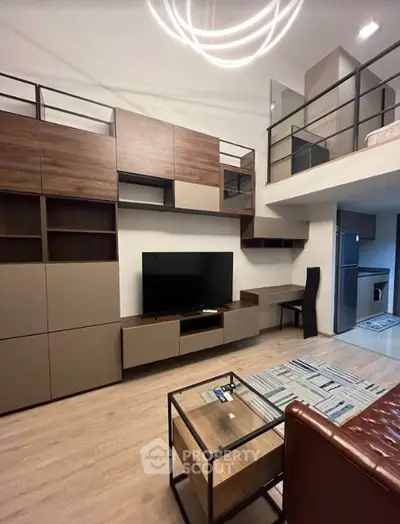 Modern living room with stylish furniture and mezzanine, featuring a sleek TV unit and contemporary lighting.