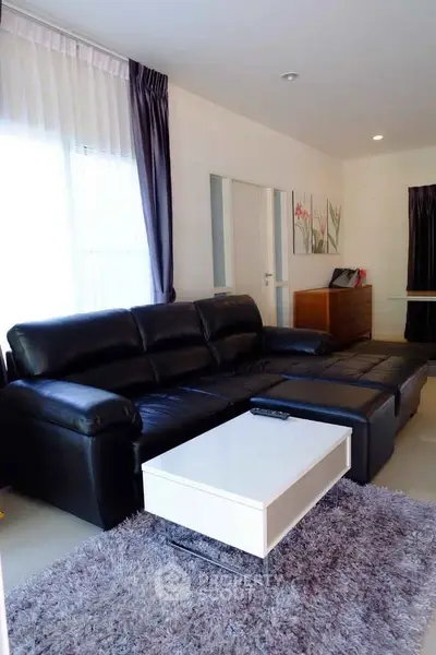 Modern living room with black leather sofa and stylish decor