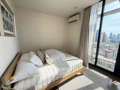 Cozy bedroom with city view and balcony access in modern apartment