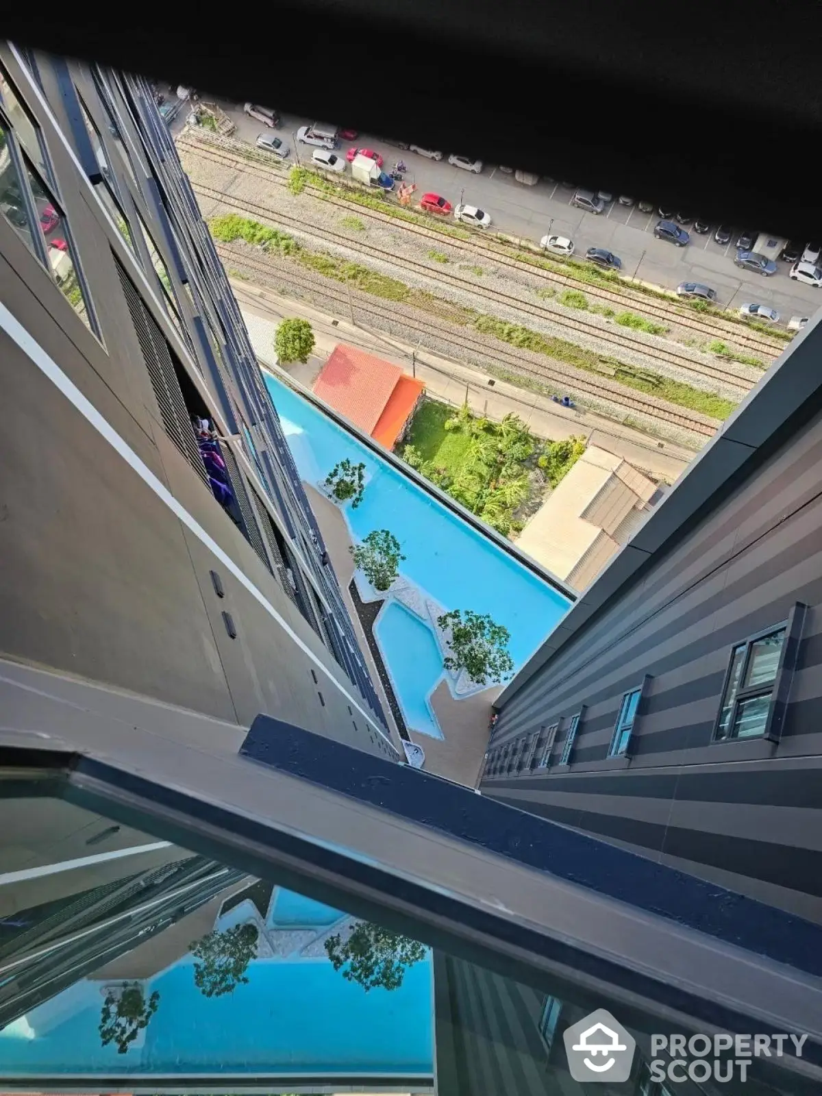 Stunning high-rise view of modern building with pool and urban landscape.