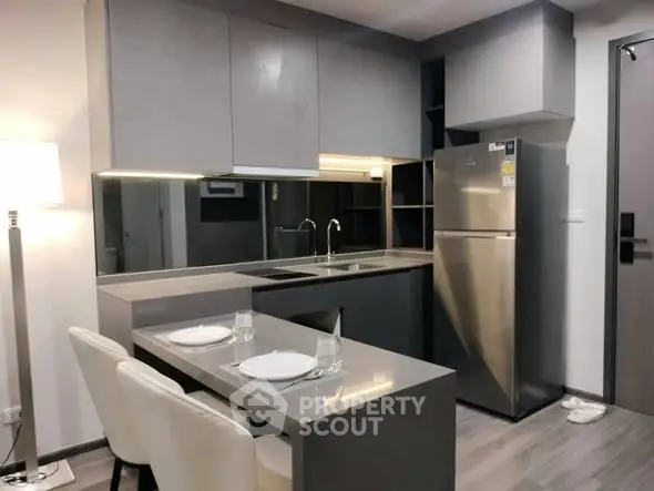Modern kitchen with sleek cabinetry and stainless steel appliances in a stylish apartment.