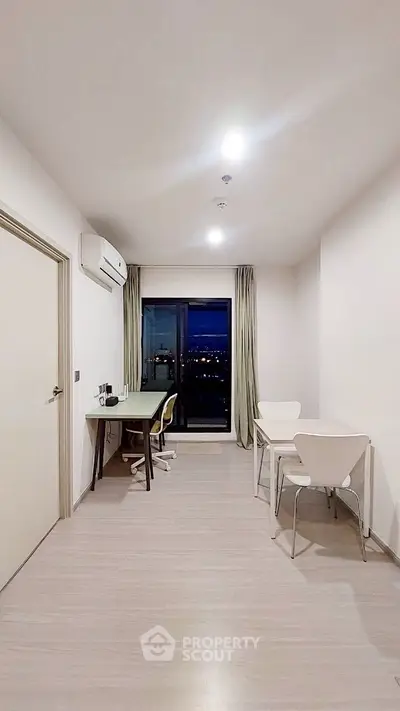 Modern study room with city view, sleek furniture, and ample lighting.