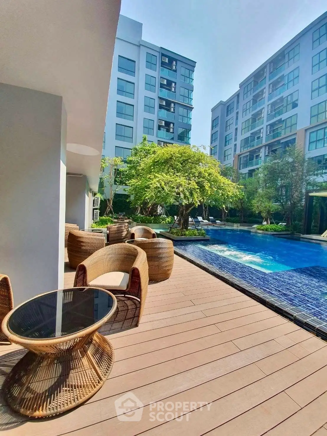 Luxurious apartment complex with poolside seating and modern architecture