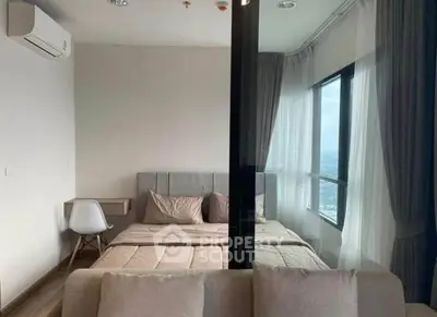 Modern bedroom with large windows and stylish decor in a high-rise apartment.