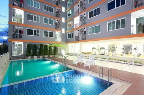 Modern apartment building with pool and gym facilities at dusk.