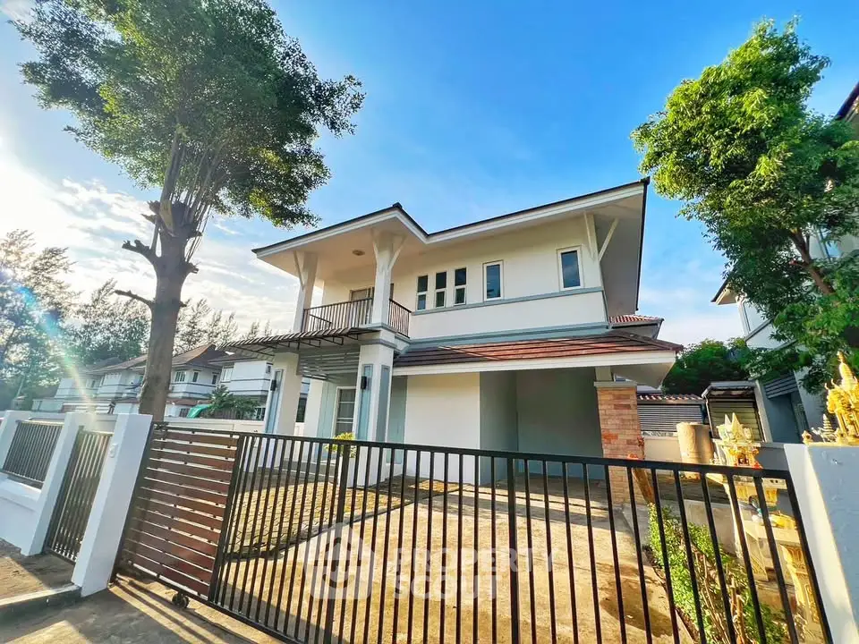 Stunning modern two-story house with spacious driveway and lush greenery.