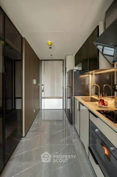 Modern kitchen with sleek design, featuring built-in appliances and elegant marble flooring.
