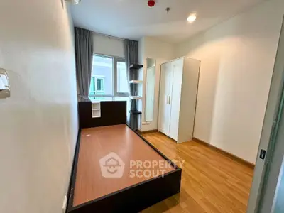 Cozy bedroom with wooden flooring and modern furniture in a bright apartment.