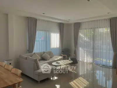 Spacious modern living room with elegant furniture and large windows for natural light.