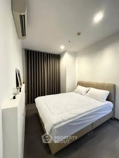 Modern bedroom with cozy bed and sleek design in a stylish apartment.