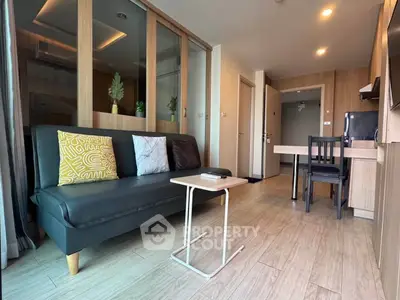Modern living room with stylish decor and open layout, featuring a cozy sofa and dining area.