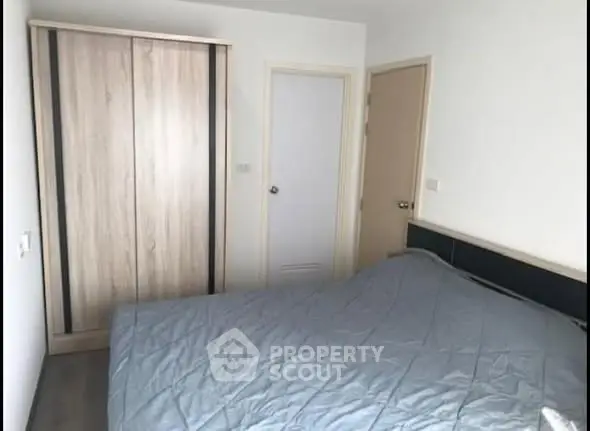 Cozy bedroom with modern wardrobe and stylish bedding in a contemporary apartment.