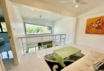 Modern loft-style living area with large window and contemporary decor