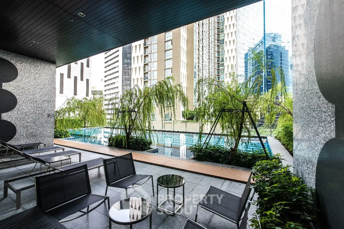 Luxurious urban poolside area with modern seating and lush greenery, offering a serene city escape.