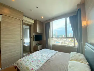 Modern bedroom with city view, featuring large window and stylish decor.