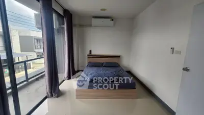 Modern bedroom with large windows and balcony access in a contemporary apartment.