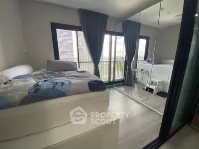 Modern bedroom with mirrored closet and city view from large windows