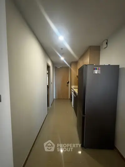 Modern hallway with sleek appliances and wooden cabinetry