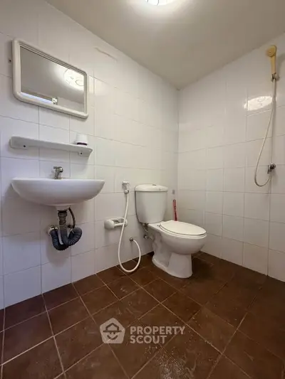 Spacious bathroom with modern fixtures and tiled flooring, featuring a shower and toilet.